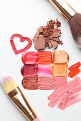 Different cosmetic products and makeup brushes on white background, flat lay