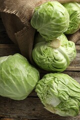 Fresh whole cabbages on wooden table, flat lay