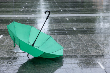 Green umbrella on wet asphalt outdoors, space for text