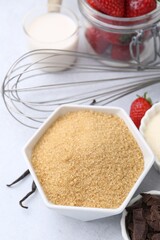 Different ingredients for panna cotta. Milk, sugar, vanilla, chocolate and strawberries on white table, closeup
