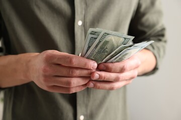 Man counting his money indoors, closeup view