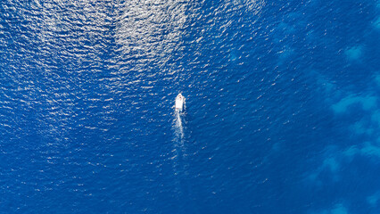 Un petit bateau en plein milieu de la mer Méditerranée avec un eau paradisiaque bleu turquoise  