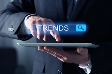 Businessman using tablet computer to find hot tendencies, new ideas, popular directions, closeup....
