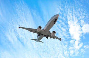 Airplane flying in beautiful blue sky with clouds