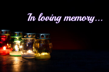 In loving memory. Many different grave lights on table in darkness