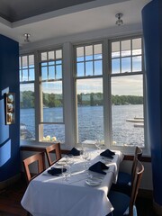 window of a restaurant facing a body of water with a nicely set table