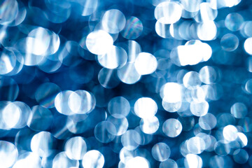 Abstract blue lights shimmer and sparkle, creating a bokeh effect. Soft circular shapes form a...