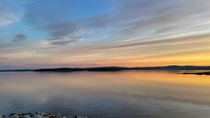 Sunset over the White Sea paints the sky and calm waters with soft pastel hues, creating a tranquil Arctic evening on the Kola Peninsula coast.
