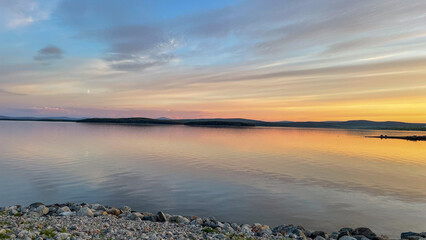  Sunset over the White Sea paints the sky and calm waters with soft pastel hues, creating a tranquil Arctic evening on the Kola Peninsula coast.
