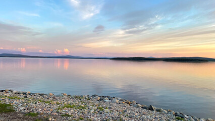  Sunset over the White Sea paints the sky and calm waters with soft pastel hues, creating a tranquil Arctic evening on the Kola Peninsula coast.