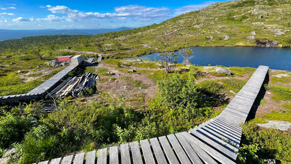 Wooden trail leading to a lake in Murmansk Oblast, Russia. Surrounded by rocky hills and untouched wilderness, it’s a peaceful northern landscape perfect for hiking.