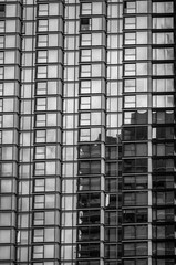 Modern Glass Building with a Reflection of a Second Building in Black and White.