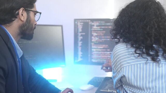 A senior software engineer leads a code review session, mentoring his diverse team on a complex project. Concept for agile development, knowledge transfer, and teamwork.