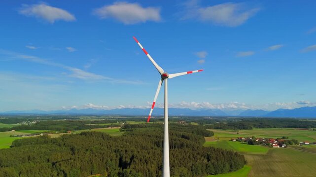 Aerial view of wind turbine in Bavaria, Ebersberg region, Germany. Luftaufnahme einer Windturbine vor dem Hintergrund der Alpen in Bayern, Deutschland. Wind turbine on golf course overlooking alps. 