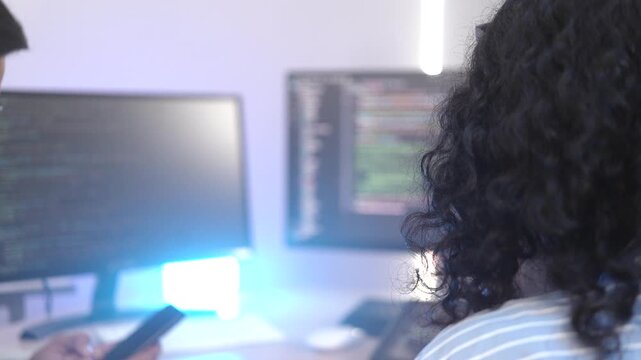 A senior software engineer leads a code review session, mentoring his diverse team on a complex project. Concept for agile development, knowledge transfer, and teamwork.