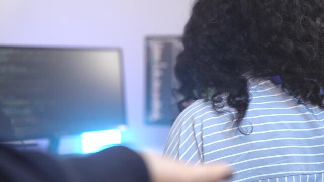 Two female software developers in a pair programming session, debugging complex code on a screen. Concept for agile development, code review, and problem-solving in tech.