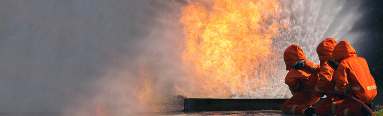 Firefighter Rescue training in fire fighting extinguisher. Firefighter fighting with flame using...