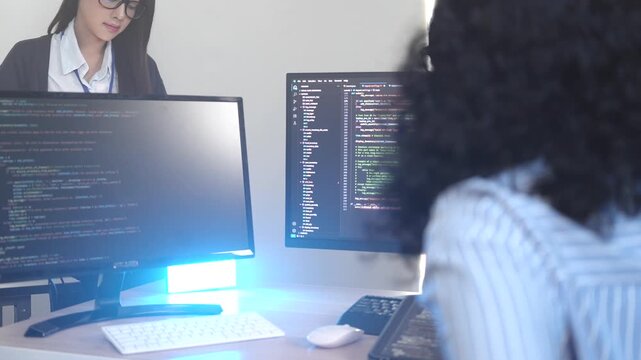 A senior software engineer leads a code review session, mentoring his diverse team on a complex project. Concept for agile development, knowledge transfer, and teamwork.