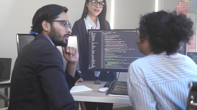 A senior software engineer leads a code review session, mentoring his diverse team on a complex project. Concept for agile development, knowledge transfer, and teamwork.