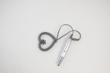 aesthetician skin therapy wand for facials with chord shaped like a heart on white background