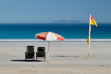 Chairs, an umbrella and a flag on Cable Beach - Broome, WA, Australia