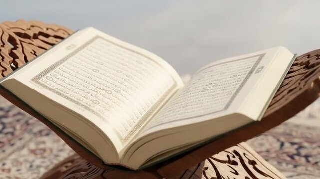 Open Qur&rsquo;an on Wooden Bookstand Showing Illuminated Page

