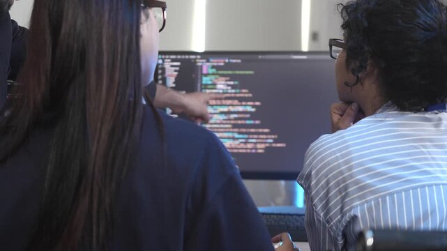 A team of female software developers in a pair programming session, reviewing and debugging code together. Concept for Women in Tech, agile development, and collaboration.