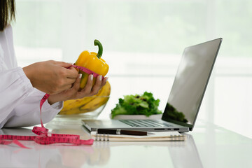 A professional dietitian consults with patients online, discussing nutrition, weight loss, and healthy eating habits using a laptop in a clinic setting.