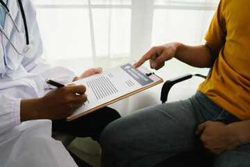 A male patient consults a doctor during a medical exam focused on prostate or testicular health,...