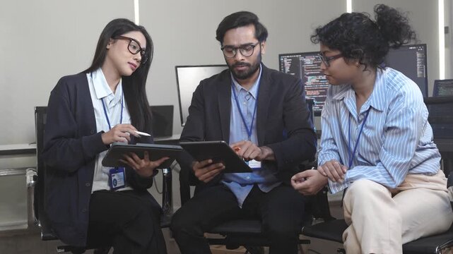 A diverse team including an Indian professional brainstorms on a tablet about Web3 and Metaverse strategies for their tech startup. Concept for decentralized innovation and digital transformation.