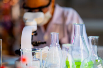 Female scientist analyzes a plant sample under a microscope in a modern biotechnology lab. Concept...