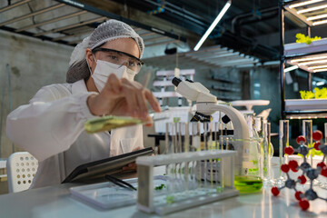 Female scientist in a sterile lab coat and gloves prepares for research in a futuristic...