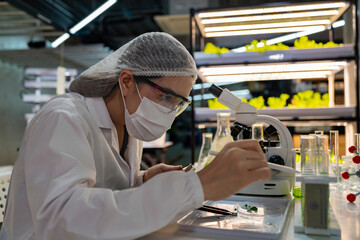 Female scientist in a sterile lab coat and gloves prepares for research in a futuristic...
