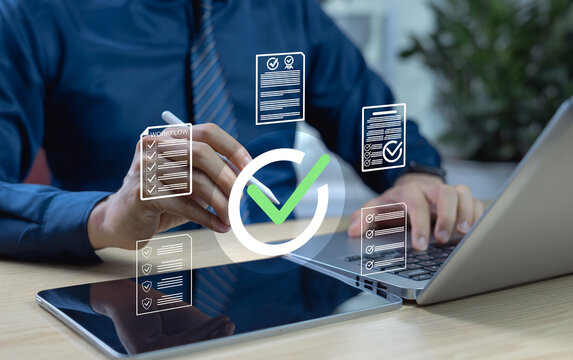 Businessman hand holding pen marking check sign on document. Concept of quality control, certification assurance, compliance, and standard verification in business processes.