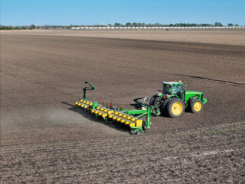 Ottawa, Illinois - USA - April 27, 2025 Aerial view of a John Deere 8320 tractor pulling a John Deere 1770NT 16 row planter