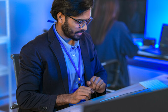 A software developer or financial analyst working late, coding on multiple screens and a foldable device. Concept for FinTech, app development, and stock trading algorithms.