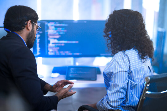 Two diverse software developers celebrate a breakthrough, happily discussing a successful project. Concept for teamwork, innovation, and success in the tech industry. - Powered by Adobe