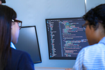A senior software engineer leads a code review session, mentoring his diverse team on a complex project. Concept for agile development, knowledge transfer, and teamwork.