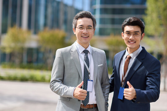 Businessmen making thumbs up gesture