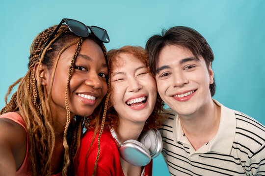 Portrait of diverse Generation Z friends posing on isolated blue screen.