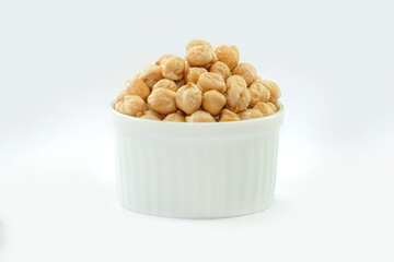 Chickpeas in a bowl on a white background. Scientific name: Cicer arietinum) is a plant in the...