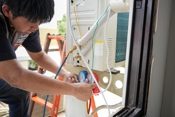 Professional Installing or Repairing an Air Conditioning System, HVAC Technician Connecting Pipes...