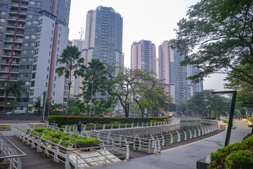 View of Jakarta's public park in the morning with a clean river and modern buildings in the background