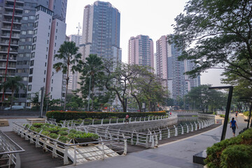 Fototapeta premium View of Jakarta's public park in the morning with a clean river and modern buildings in the background