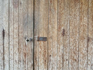Old and vintage wooden door with texture in warm brown tone for background and decorations