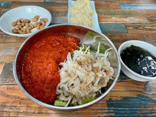 Mulhoe, cold raw fish soup in a restaurant in Seoul, South Korea. Icy bath of red pepper broth. Traditional local Korean food. Raw fish with vegetable and red chilli paste sauce
