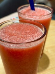 Two glasses of fresh watermelon juice with straws on it. Healthy drinks sold in cafe