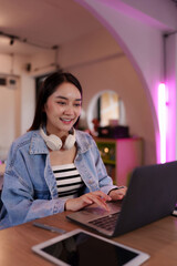 Asian woman freelancer digital nomad works laptop coworking space modern studio happy professional...