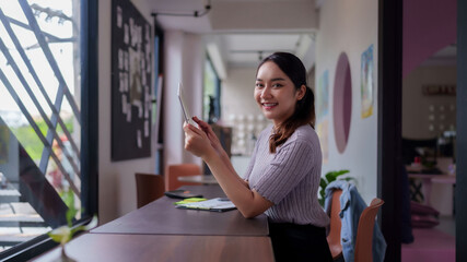 Asian adult woman freelancer digital nomad working tablet coworking space modern productive...