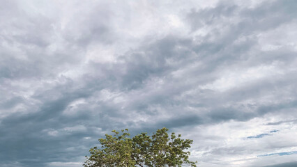 Clouds between innocent white and gloomy floating side by side in the sky on a day when the sky is...
